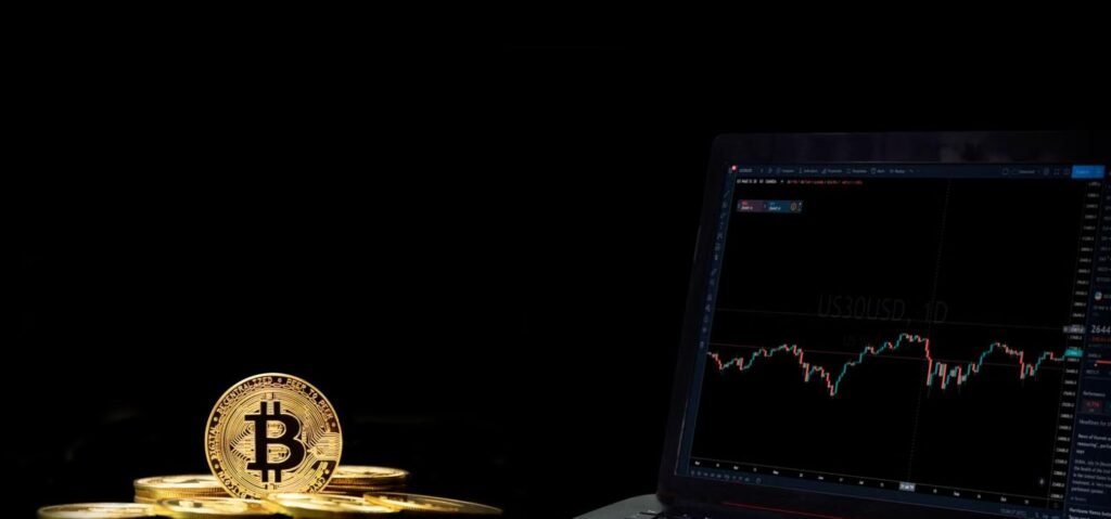 Bitcoin coin next to laptop trading chart, representing best crypto exchanges for Pakistani investors