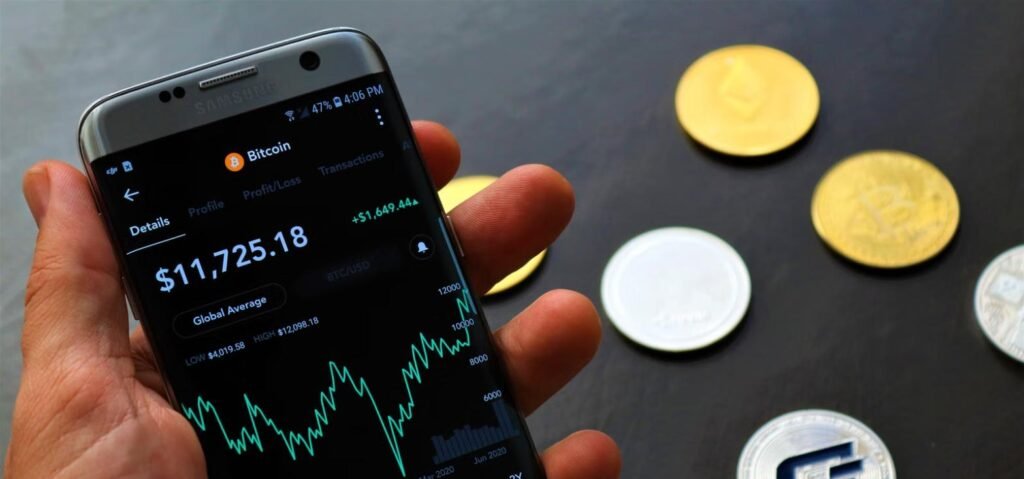 Hand holding phone showing Bitcoin trading app, representing how to buy Bitcoin in Pakistan