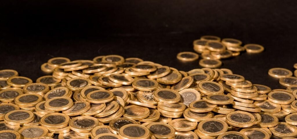 Pile of gold coins representing digital gold versus physical gold investment in Pakistan