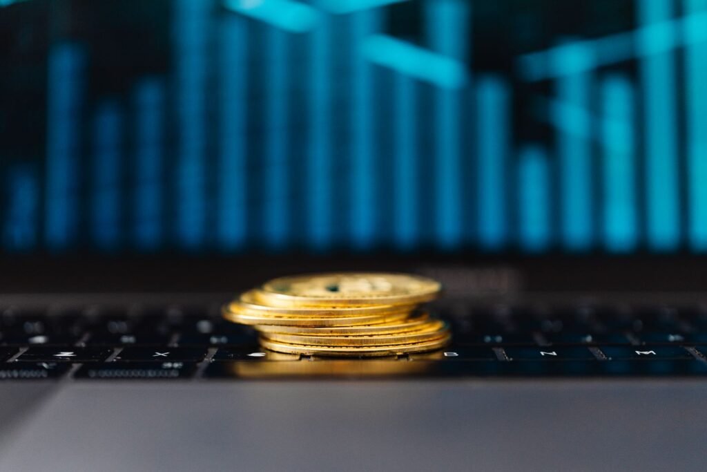 Best investment in Pakistan shown through gold coins, a laptop, and a rising growth graph