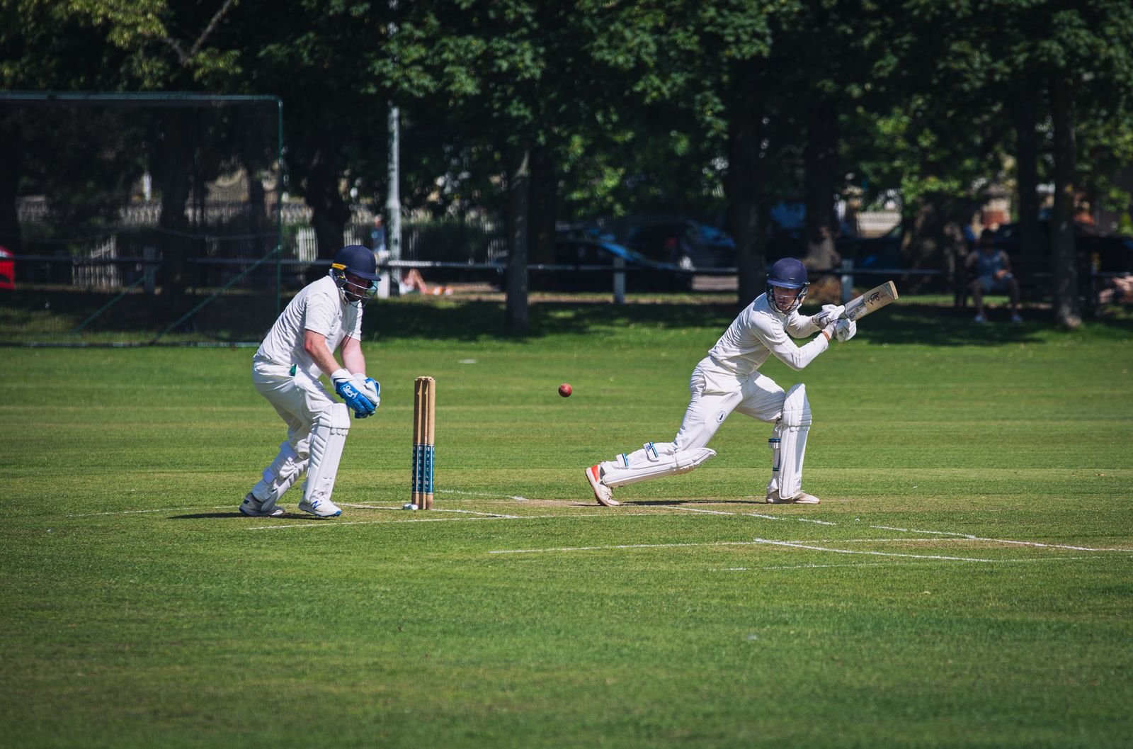 Cricket player in white uniform on a green field during a domestic match