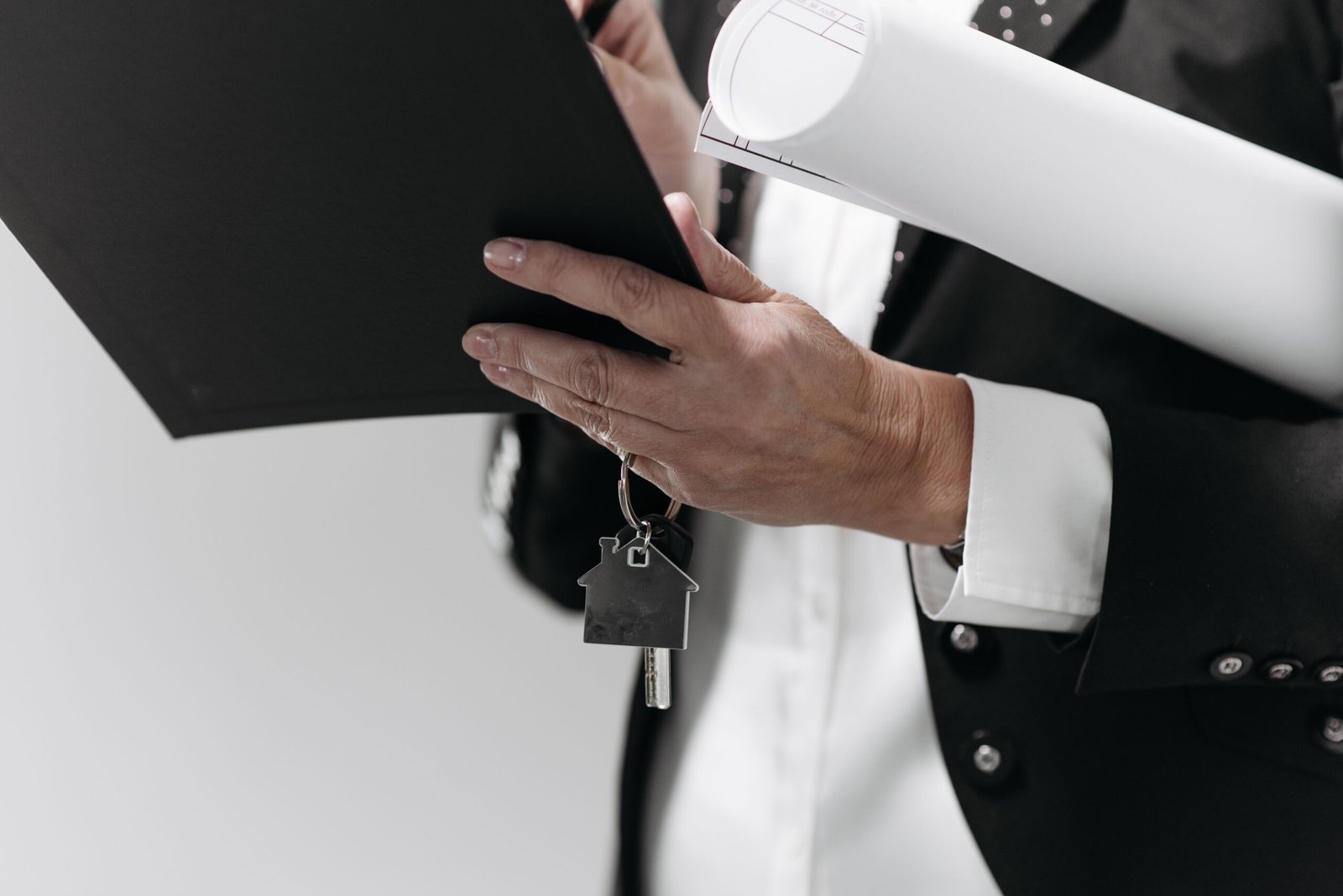 Person reviewing home loan paperwork and house key before signing mortgage documents