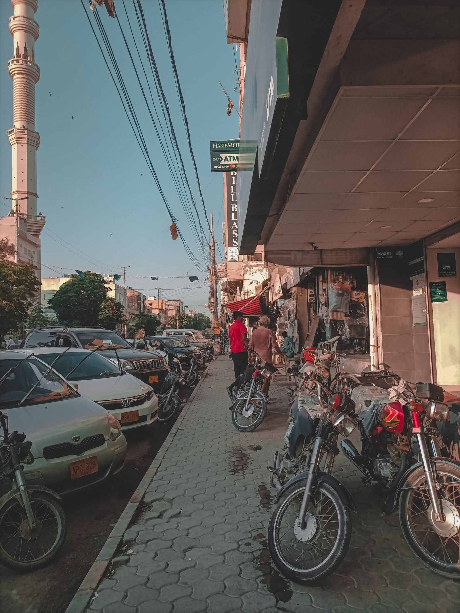 Motorbikes used for ride-hailing and food delivery parked on a Pakistani city street