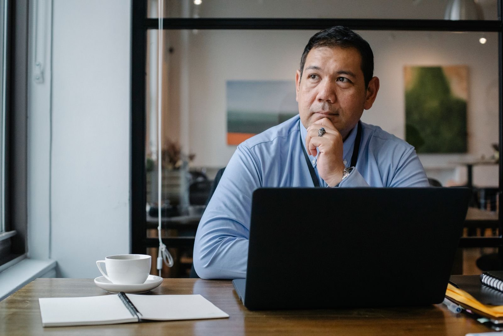Entrepreneur working thoughtfully on a laptop in an office setting