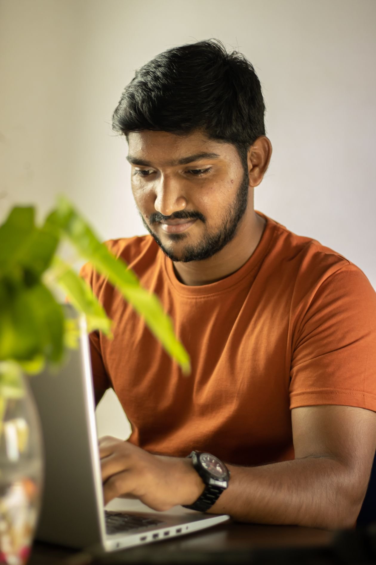 Man working intently on a laptop from home, representing Pakistan's growing freelance export economy