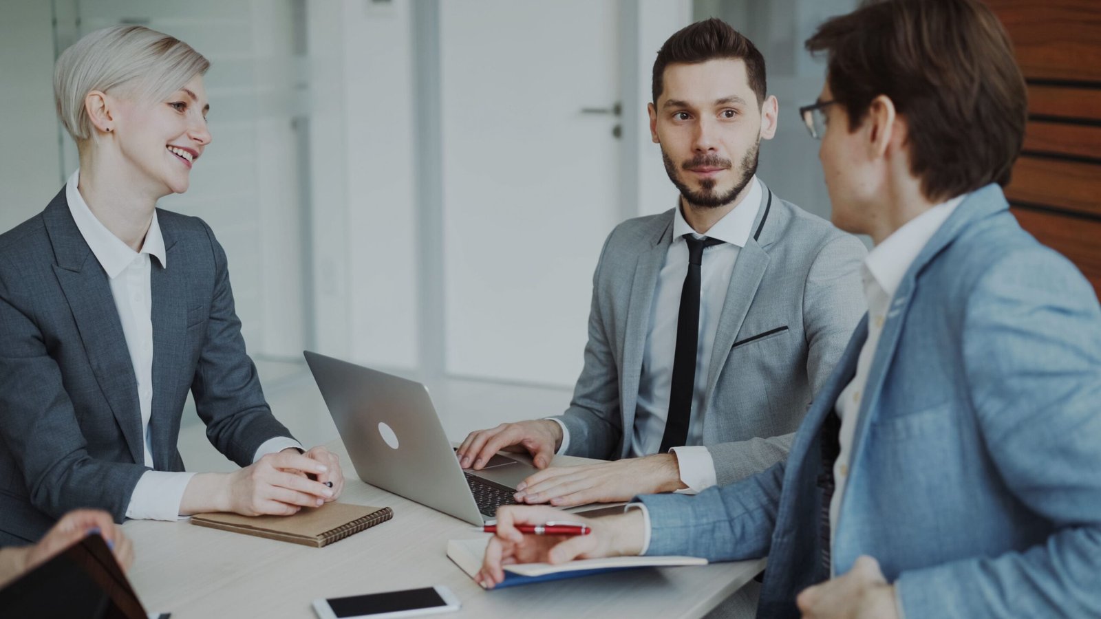 Startup founders and investors discussing a funding strategy around a table in a modern office