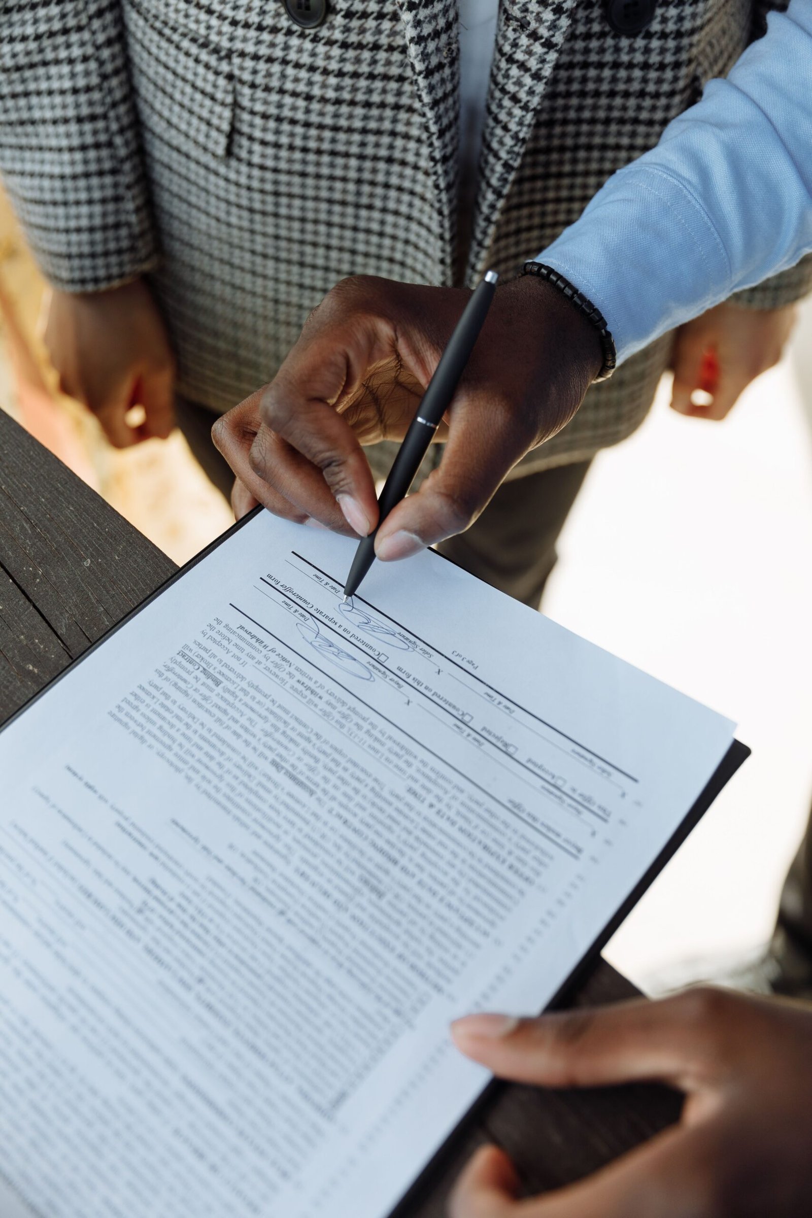 Buyer signing property documents after verifying a housing scheme's legal status