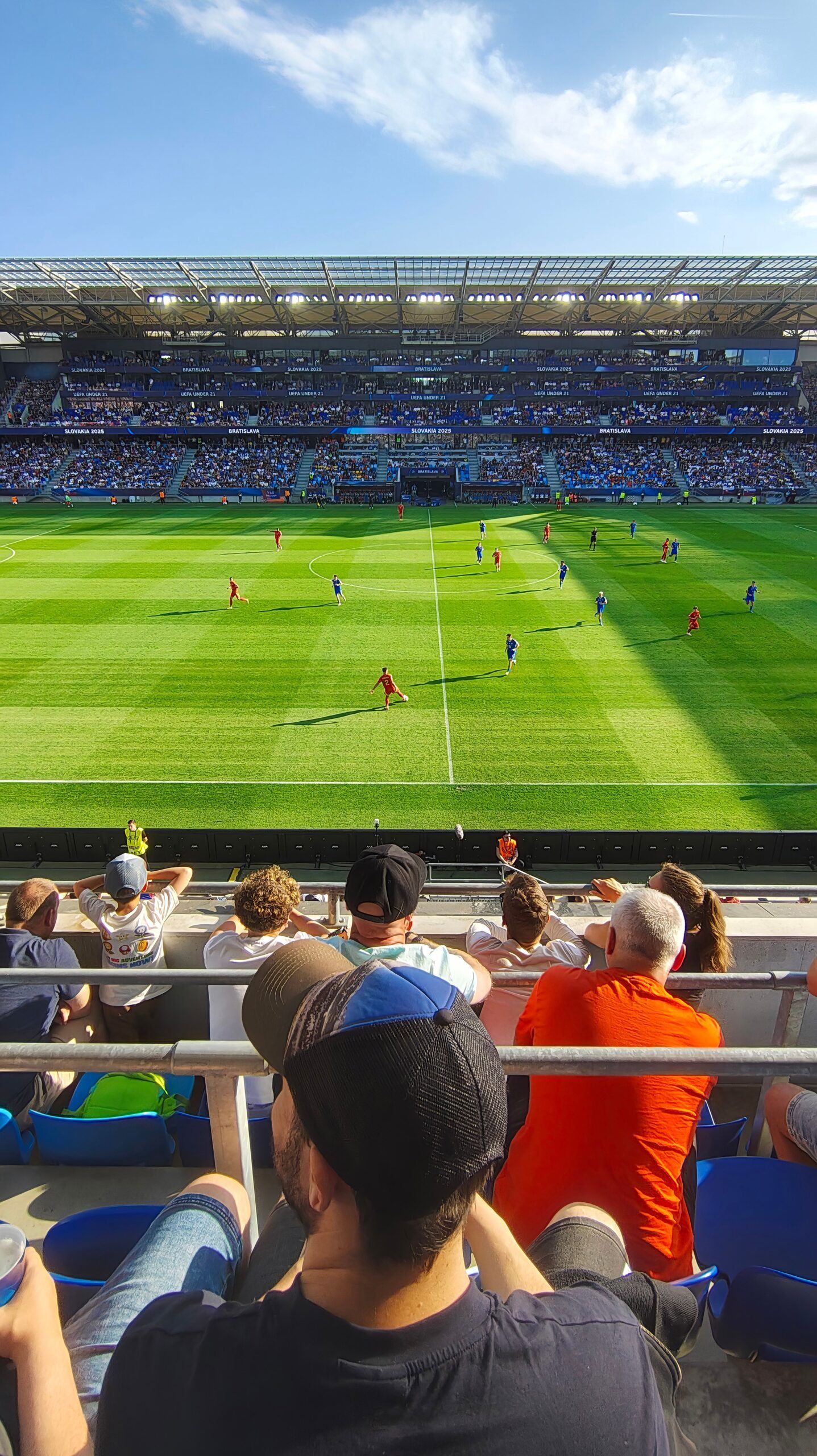 Players competing during a football match in a packed stadium