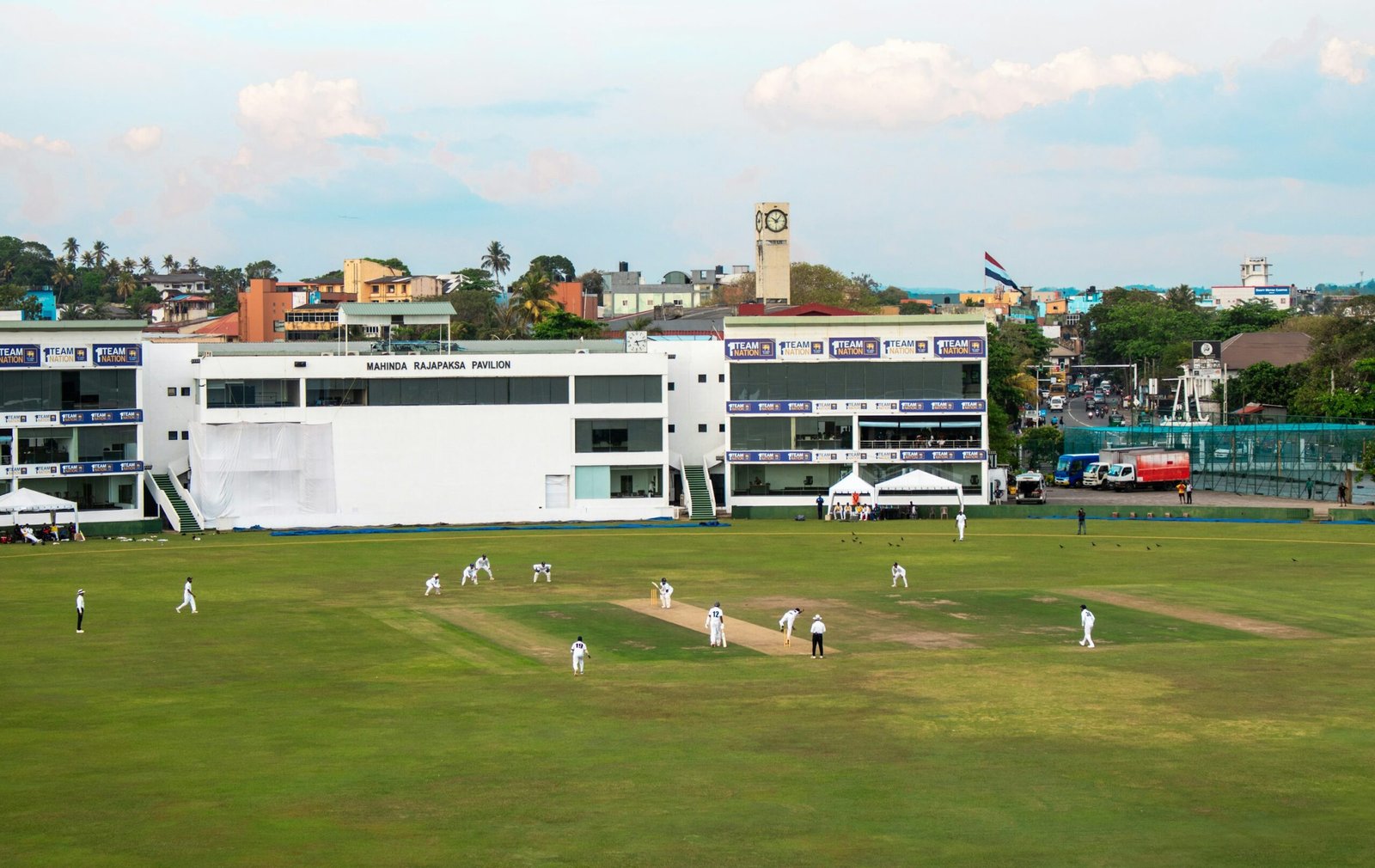 Cricket match in progress on the field at a stadium